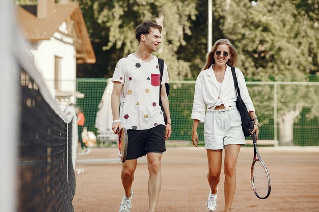 Junges Paar auf Tennisplatz. Zwei Tennisspieler in Sportkleidung.