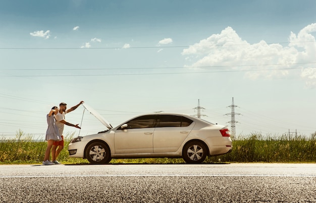 Junges Paar, das an sonnigem Tag auf dem Auto reist