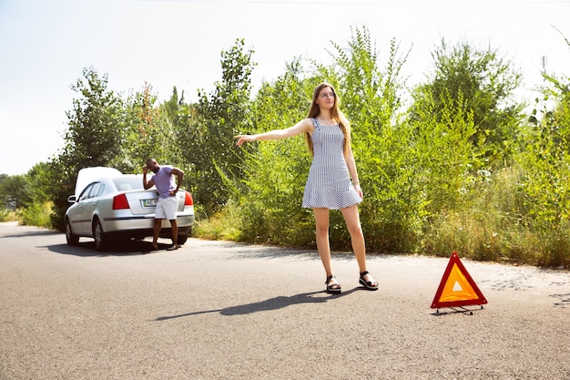 Junges Paar, das an sonnigem Tag auf dem Auto reist