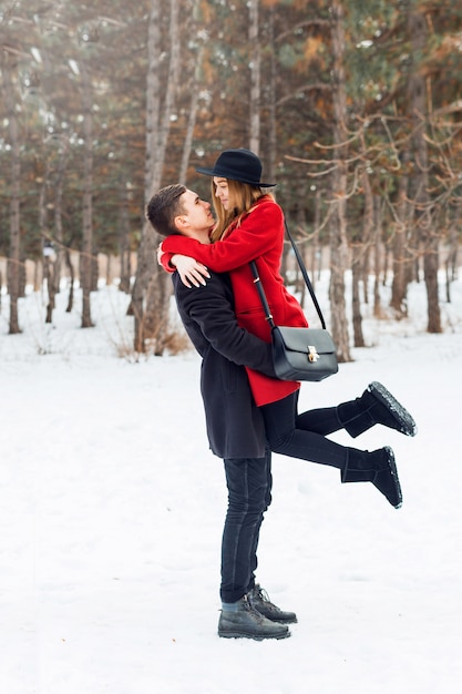 Junges Paar, das auf einem schneebedeckten Feld umarmt