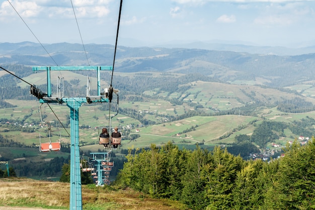 Junges Paar, das auf Skilift hinuntergeht