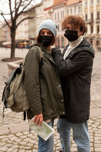 Junges Paar, das draußen mit medizinischen Masken aufwirft