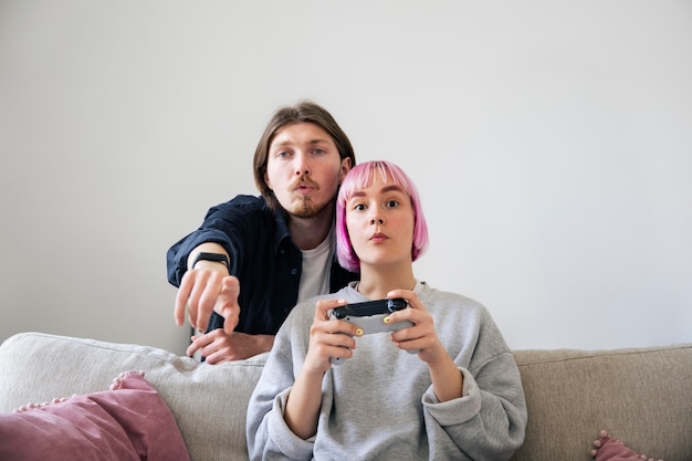 Junges Paar, das ein Videospiel zu Hause spielt