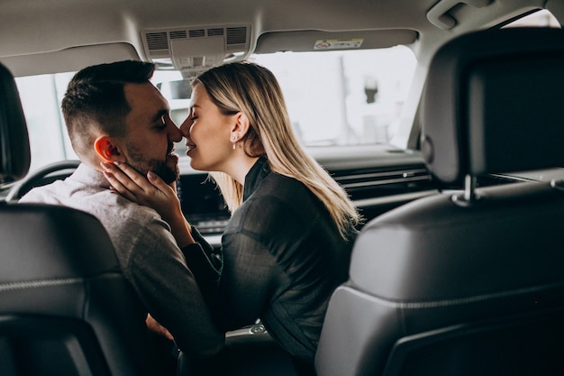 Kostenloses Foto junges paar, das im auto sitzt und küsst