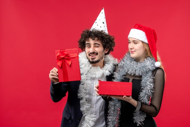 Junges Paar, das Neujahrsgeschenk-Weihnachtsliebesfeier eröffnet
