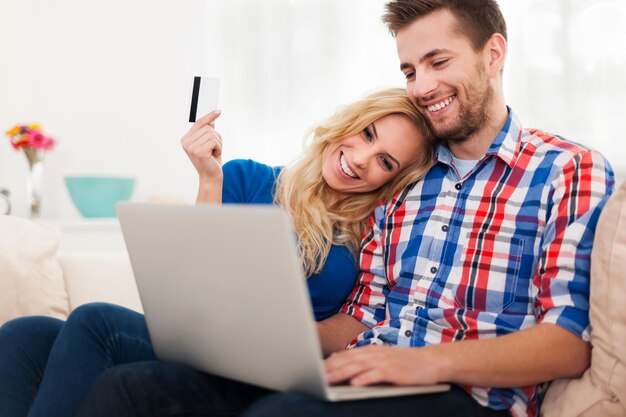 Junges Paar, das online mit Kreditkarte zahlt