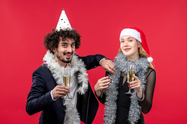 Junges Paar der Vorderansicht, das gerade neues Jahr auf roter Schreibtischparty-Weihnachtsliebe feiert