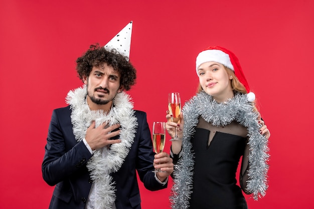Junges Paar der Vorderansicht, das gerade neues Jahr auf Weihnachtsliebe der roten Wandparty feiert