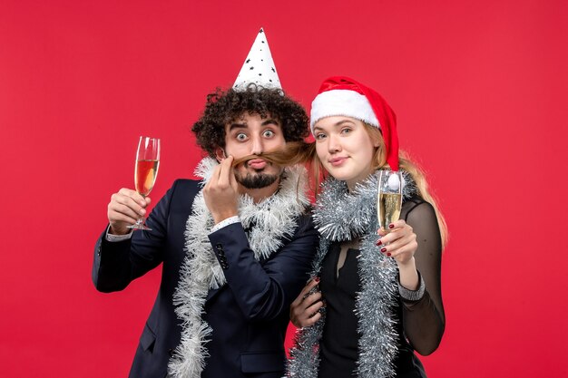 Junges Paar der Vorderansicht, das neues Jahr auf Weihnachtsliebesfeier der roten Wand feiert