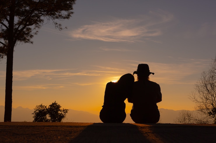 Kostenlose Foto junges paar genießt den sonnenuntergang im berg