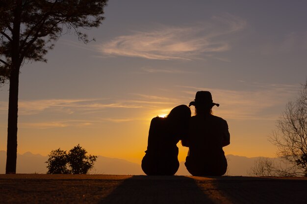 Junges Paar genießt den Sonnenuntergang im Berg