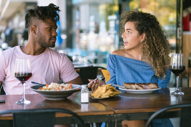 Junges Paar genießt und verbringt gute Zeit zusammen, während es ein Date in einem Restaurant hat.