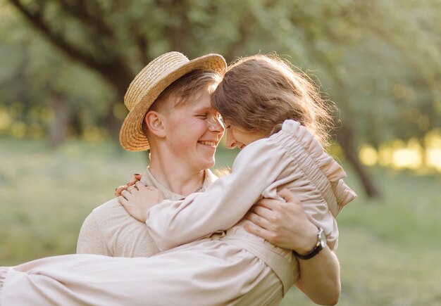 Junges Paar in der Liebe im Freien. Atemberaubendes sinnliches Porträt im Freien des jungen stilvollen Modepaares, das im Sommer im Feld aufwirft