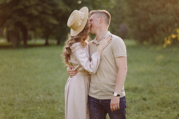 Junges Paar in der Liebe im Freien. Atemberaubendes sinnliches Porträt im Freien des jungen stilvollen Modepaares, das im Sommer im Feld aufwirft