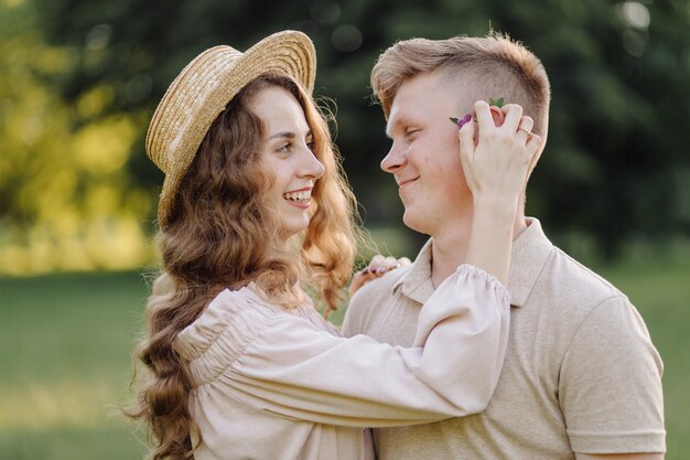 Junges Paar in der Liebe im Freien. Atemberaubendes sinnliches Porträt im Freien des jungen stilvollen Modepaares, das im Sommer im Feld aufwirft