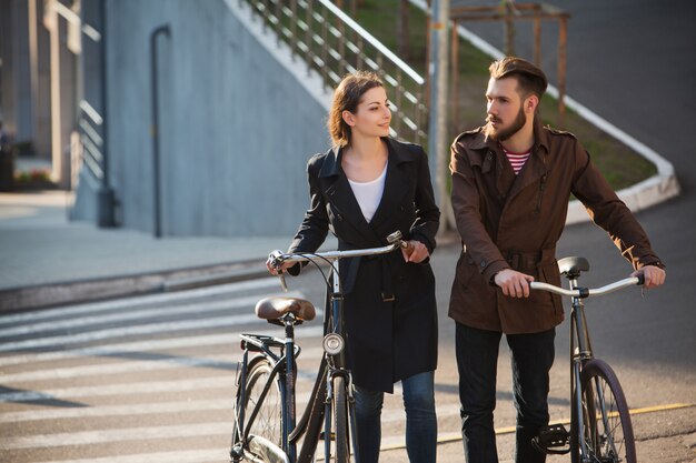 Junges Paar mit auf einem Fahrrad gegenüber Stadt
