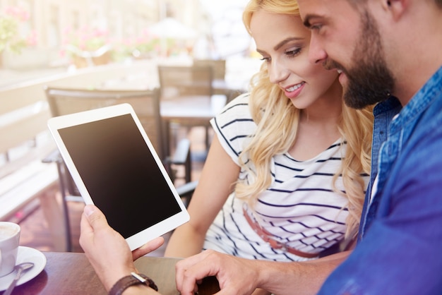 Junges Paar mit digitaler Tablette im Café