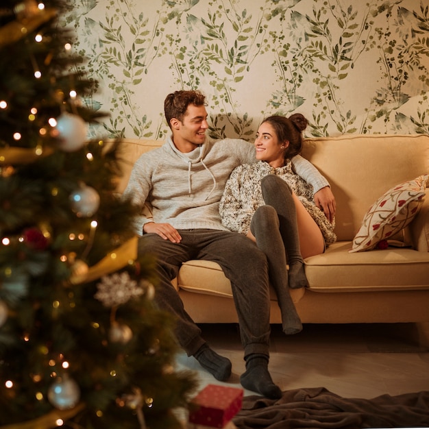 Kostenloses Foto junges paar sitzt auf der couch