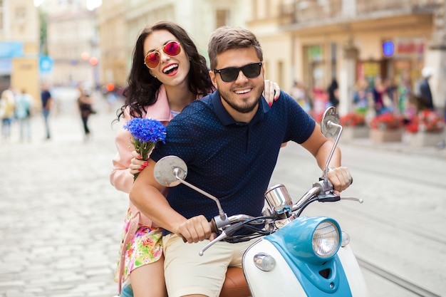 Junges schönes Hipster-Paar, das auf Motorradstadtstraße reitet