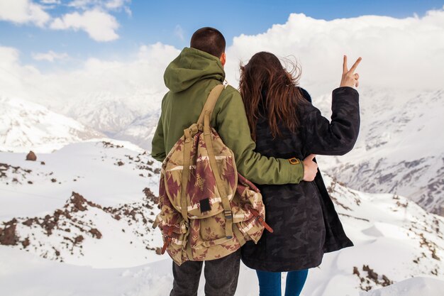 Junges schönes Hipsterpaar, das in den Bergen wandert, Winterferienreisen, Mann Frau in Liebesansicht von hinten