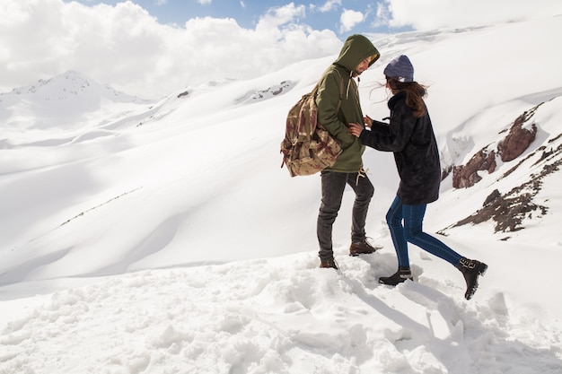 Junges schönes Hipsterpaar, das in den Bergen wandert, Winterferienreisen, Mannfrau in der Liebe