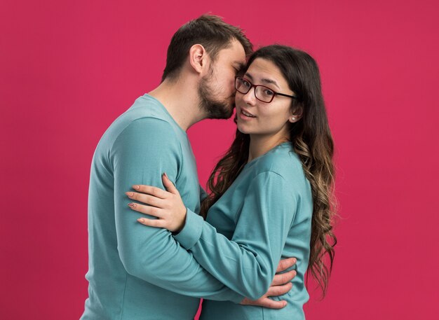 Junges schönes Paar in blauer Freizeitkleidung Mann und Frau umarmen Mann, der seine glückliche Freundin küsst