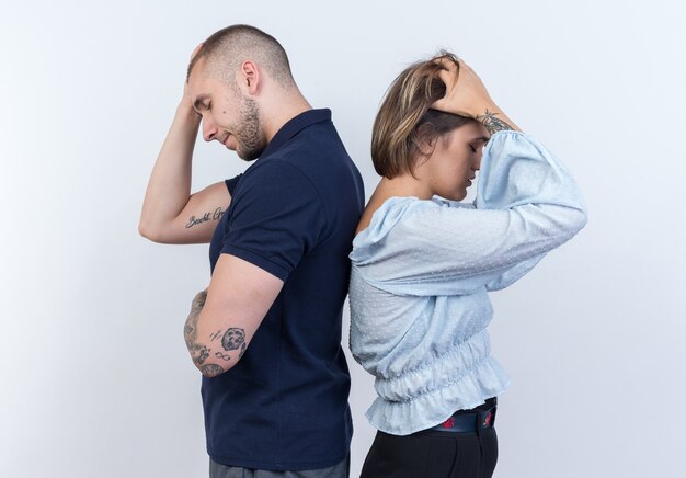 Junges schönes Paar Mann und Frau streiten Rücken an Rücken über weiße Wand back