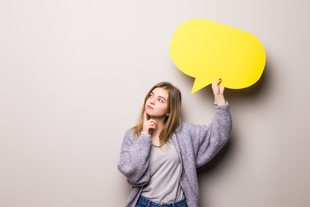 Kostenloses Foto junges schönes träumendes mädchen, das eine gelbe blase für text hält, lokalisiert