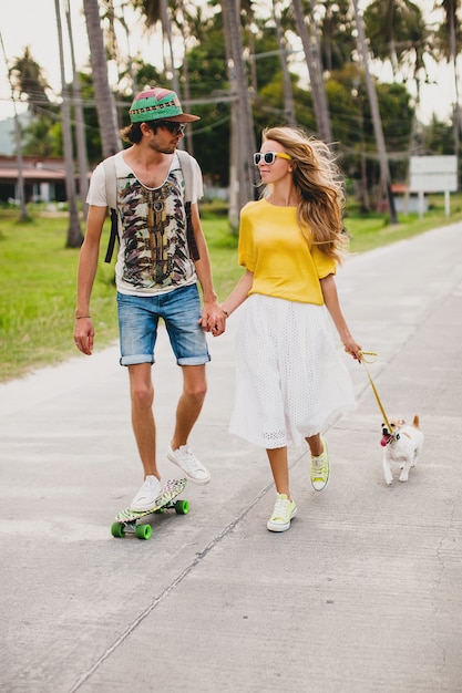 Junges stilvolles hipster-paar verliebt in urlaub mit hund und skateboard, spaß habend