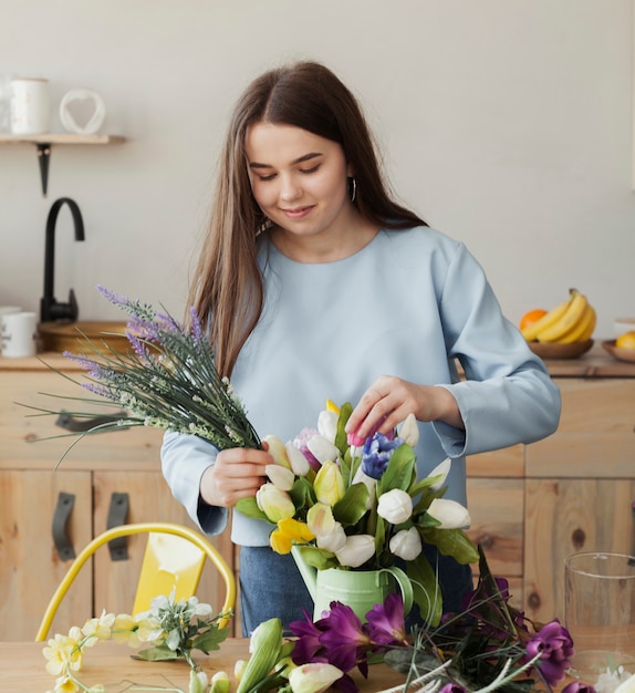 Kostenloses Foto junges süßes mädchen, das einen blumenstrauß schafft