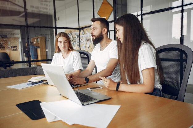 Junges Team, das zusammenarbeitet und den Laptop benutzt