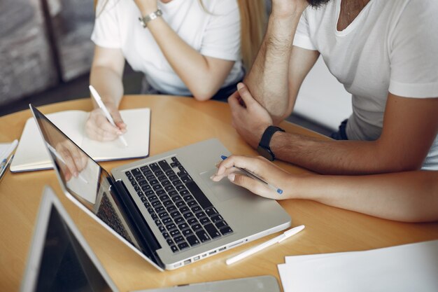 Junges Team, das zusammenarbeitet und den Laptop benutzt