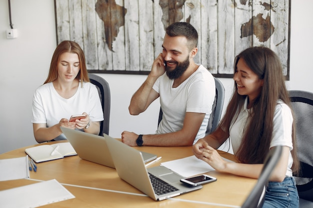 Junges Team, das zusammenarbeitet und den Laptop benutzt