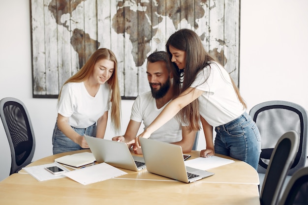 Junges Team, das zusammenarbeitet und den Laptop benutzt