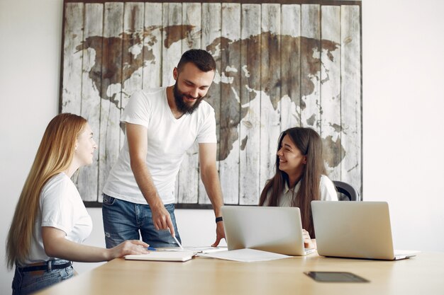 Junges Team, das zusammenarbeitet und den Laptop benutzt