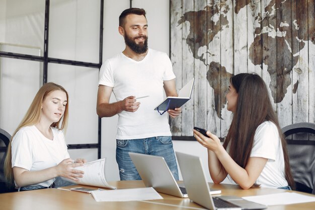 Junges Team, das zusammenarbeitet und den Laptop benutzt