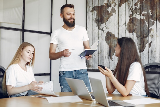 Junges Team, das zusammenarbeitet und den Laptop benutzt