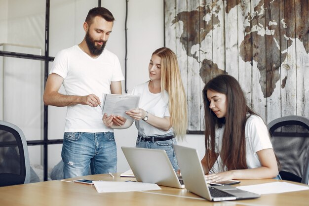 Junges Team, das zusammenarbeitet und den Laptop benutzt