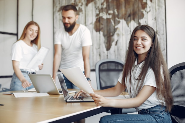 Junges Team, das zusammenarbeitet und den Laptop benutzt