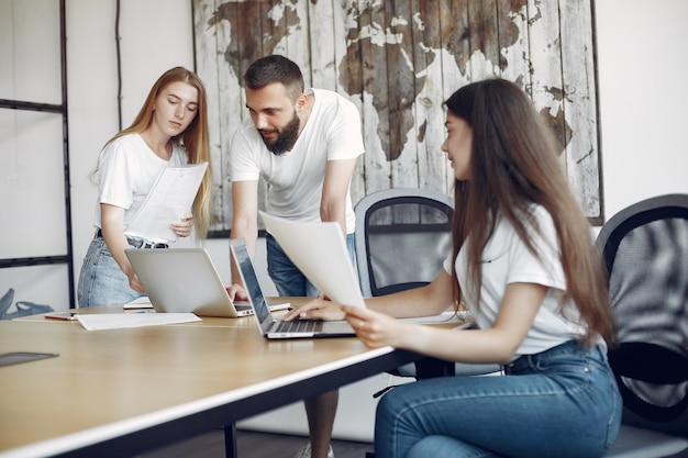 Junges Team, das zusammenarbeitet und den Laptop benutzt