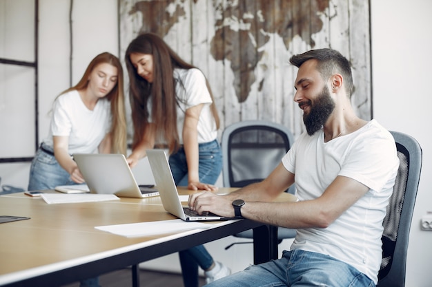 Junges Team, das zusammenarbeitet und den Laptop benutzt