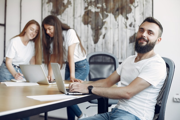 Junges Team, das zusammenarbeitet und den Laptop benutzt