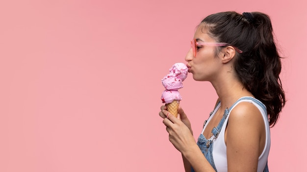 Junges Teenager-Mädchen mit Sonnenbrille, das ein Eis isst