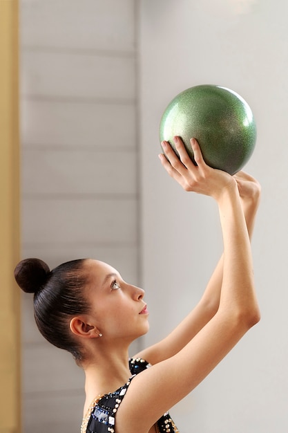 Kostenloses Foto junges turnertraining mit ball im fitnessstudio