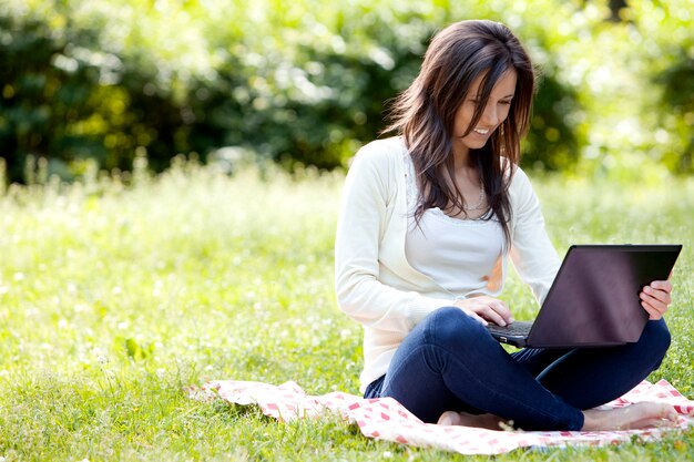 Junges und glückliches Mädchen mit Laptop