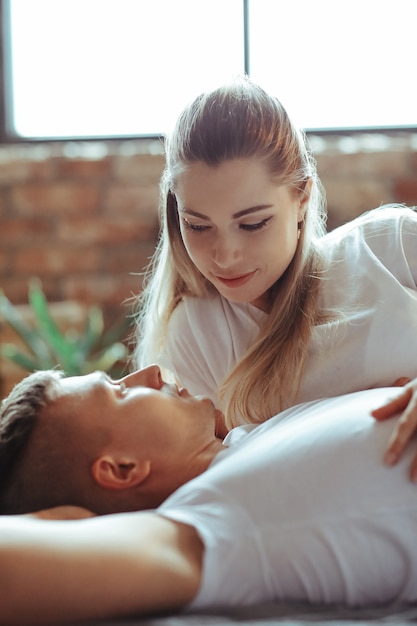 Junges verliebtes Paar, das Zeit zusammen verbringt. Schöne Frau und schöner Mann, die intime Momente zu Hause haben