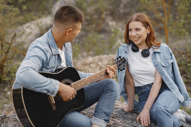 Junges verliebtes Paar, Freund, der Gitarre spielt