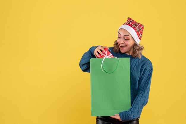 junges weibliches Haltepaket und wenig Geschenk auf gelb