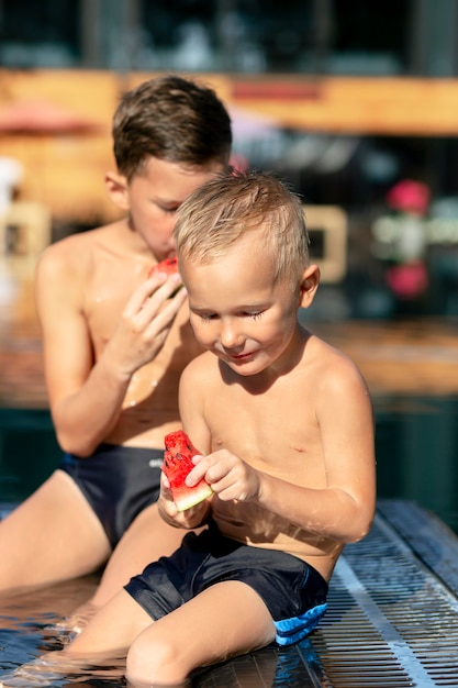 Jungs am Schwimmbad mit Wassermelone