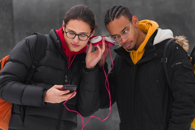 Jungs mit mittlerer Einstellung, die draußen Musik hören